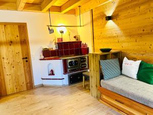 a kitchen with a stove and a couch in a room at Lärchenhaus ,,Unterer Brodl" in Kammersberg