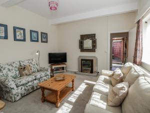 a living room with a couch and a table at Riverside Cottage in Llandrindod Wells