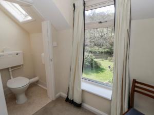 a bathroom with a toilet and a window at Riverside Cottage in Llandrindod Wells +34 photos
