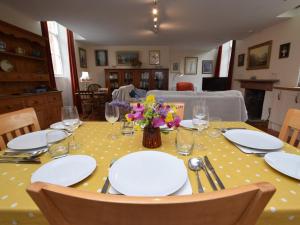 a table with plates and glasses and flowers on it at 2 Bed in Biggar oc-ca366 in Biggar +14 photos