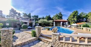 a home with a pool and a gazebo at Villa Stone House Poplat in Vela Luka