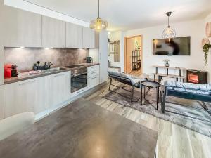 a kitchen with white cabinets and a table and chairs at Apartment Lotus in Ovronnaz