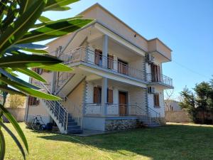 a white house with a balcony and a yard at Villa Pams in Baks-Rrjoll