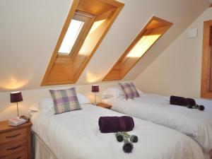 two twin beds in a room with skylights at 4 Bed in Gairloch oc-29010 in Gairloch