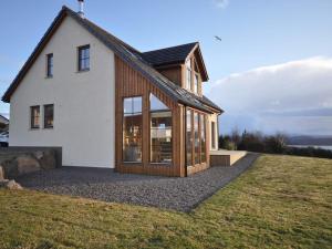 a house with large windows on top of a field at 4 Bed in Gairloch oc-29010 in Gairloch