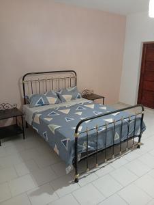 a bed with a blue comforter and pillows in a bedroom at Chez Mounas in Saint-Louis