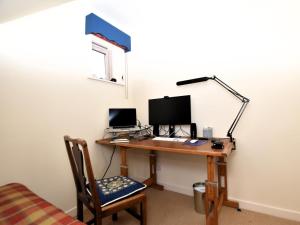 a desk with a computer and a lamp on it at 5 Bed in Aberlour oc-ca280 in Carron