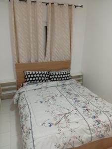 a bedroom with a large bed with a wooden headboard at Chez Mounas in Saint-Louis +7 photos