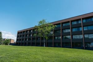 an office building with a green lawn in front of it at Hôtels Gouverneur Sept-Îles in Sept-Îles