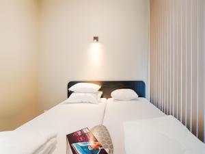 two beds in a small room with a book on a table at Amsterdam in Oud-Ade