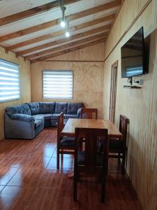 a living room with a table and a couch at cabaña zoila N in Coñaripe