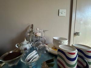 a glass table with bowls and dishes on it at The Dairy stylish chalet for 2 opp the beach 1 minute walk in Whitstable