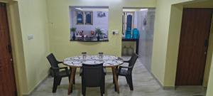 a dining room with a table and four chairs at Close2heaven 3 bedroom privacy Home with a hall and a paid kitchen in Kodaikānāl