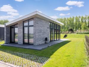 a small house with glass doors on a lawn at Leiden in Oud-Ade