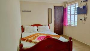 a bedroom with a bed with a red head board at Close2heaven 3 bedroom privacy Home with a hall and a paid kitchen in Kodaikānāl