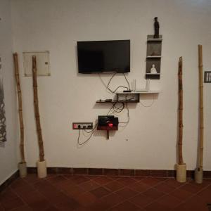 a room with a wall with a tv and some logs at Natural bliss in Tiruchirappalli
