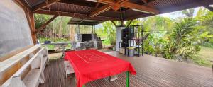 a table with a red table cloth on a deck at La tente de Cléa in Salazie