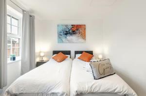 two beds in a bedroom with white walls at Charming 3-Bedroom Norwich Retreat Garden& Parking in Norwich