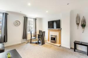 a living room with a table and a fireplace at Charming 3-Bedroom Norwich Retreat Garden& Parking in Norwich