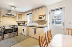 a kitchen with wooden cabinets and a table with a dining room at Charming 3-Bedroom Norwich Retreat Garden& Parking in Norwich