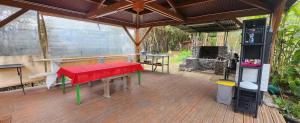 a screened porch with a red bench on a wooden deck at La tente de Cléa in Salazie