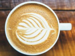 a cup of coffee sitting on a wooden table at B&B Resto al Sud 2 in Salerno +15 photos