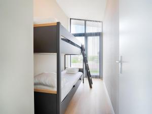 a bedroom with a bunk bed and a window at Polder in Oud-Ade