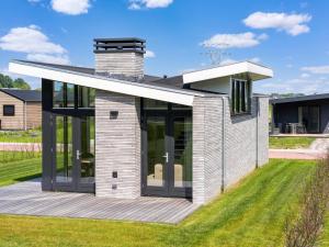a house with glass doors on a lawn at Polder in Oud-Ade