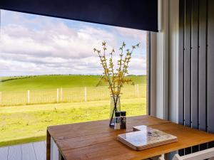 a table with a vase with flowers in a window at 1 Bed in Girvan oc-78073 in Girvan +8 photos