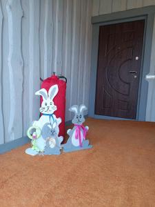three figurines of rabbits standing in front of a door at Міні садиба in Lazeshchyna