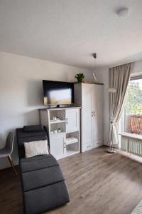 a living room with a couch and a flat screen tv at Gemütliche Auszeit in Bad Rothenfelde in Bad Rothenfelde