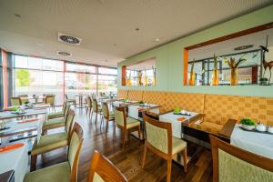 a restaurant with tables and chairs and a mirror at Qualitel Wilnsdorf in Wilnsdorf