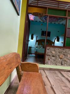 a wooden bench in a room with a bedroom at Posada Kauai Experiencia de descanso y conexión en la selva in Mocoa