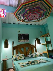 a bedroom with a bed with a colorful ceiling at Posada Kauai Experiencia de descanso y conexión en la selva in Mocoa