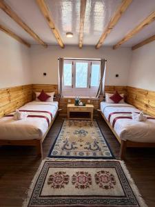a room with three beds and a table in it at Hotel Sheryang in Namche