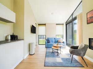 a living room with a blue couch and a table at Strand in Oud-Ade