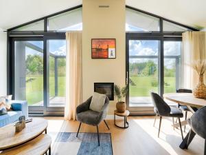 a living room with large windows and a table and chairs at Strand in Oud-Ade