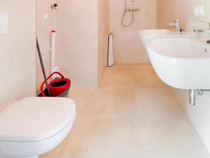 a white bathroom with a toilet and a sink at Strand in Oud-Ade +15 photos