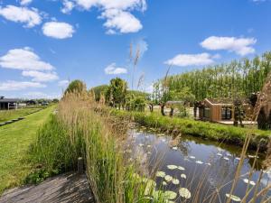 a river with tall grass next to a wooden path at Strand in Oud-Ade