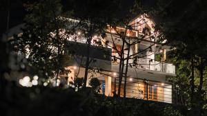 a white building with lights on it at night at Rambos Inn Homestay in Vagamon