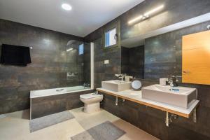 a bathroom with two sinks and a toilet and a tub at Casa Paulo - Aguilón Golf in San Juan de los Terreros +13 photos