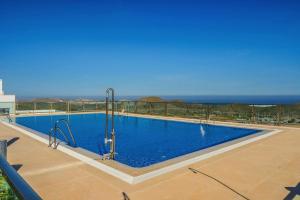 a large swimming pool with the ocean in the background at Casa Paulo - Aguilón Golf in San Juan de los Terreros