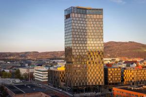 a tall yellow office building in a city at ARCOTEL Tabakfabrik Linz in Linz
