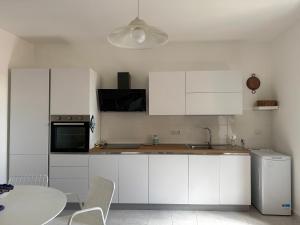 a kitchen with white cabinets and a table and a sink at La Scaletta - Charming Historic Center Home - Mountain View in San Nicola Arcella +30 photos