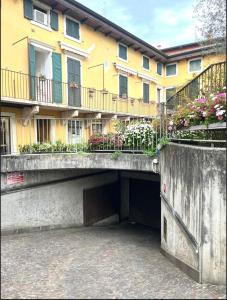 a building with a bridge with flowers on it at Residenza Arilica - Silkeys in Peschiera del Garda