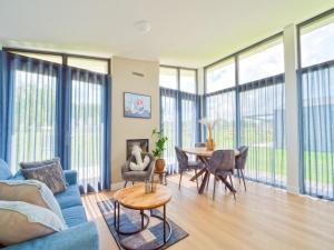 a living room with a blue couch and a table at Kaag in Oud-Ade