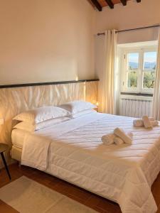 a bedroom with a large white bed with towels on it at Residenza Castelnovo in Gubbio