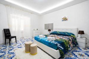 a white bedroom with a bed and a chair at Fantasy House Suites in Forio d'Ischia