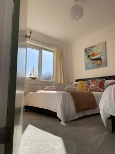 a bedroom with a large bed and a window at Simla Bungalow, Tetney, Spacious Parking, Private Garden in Tetney