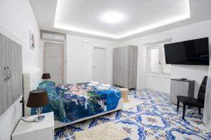 a bedroom with a bed and a flat screen tv at Fantasy House Suites in Forio d'Ischia